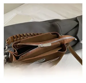 Close-up of brown leather bucket bag with silver hardware and woven handle detail