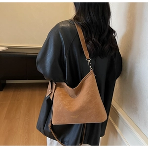 Detail view of brown faux suede tote bag with gold logo and matching mini coin purse