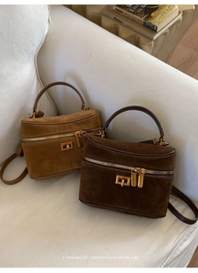 Détail de sacs à main cylindriques en daim vintage en camel et marron avec dorures