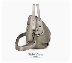 Side view of grey-green nylon crossbody bag with cylindrical handles and wide strap