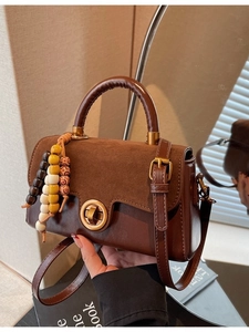 Retro brown leather handbag with gold twist lock and beaded tassel in lifestyle setting