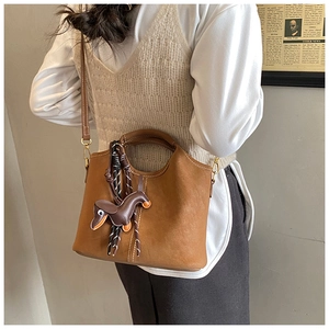 Brown frosted leather bucket bag with cute dachshund puppy charm and thin strap