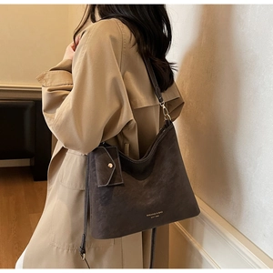 Detail of vintage brown tote bag with logo and matching side pouch on trench coat