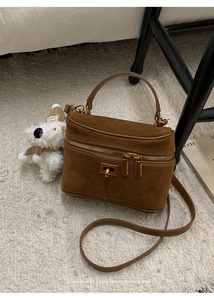 Vue détaillée d'un sac boîte en daim marron avec des finitions en métal doré