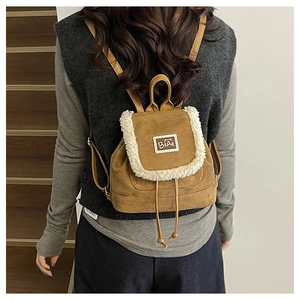 Close-up of vintage brown suede mini backpack with plush faux shearling trim and bear label