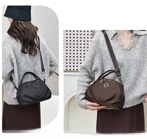 Detail view of nylon crossbody bag with round logo and adjustable shoulder strap