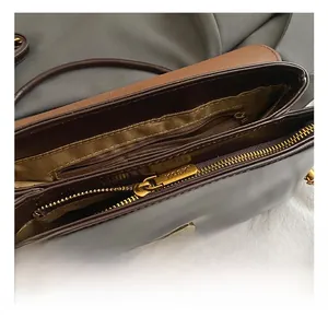 Detail view of the multi-layer interior and gold zipper pull on the vintage shoulder bag