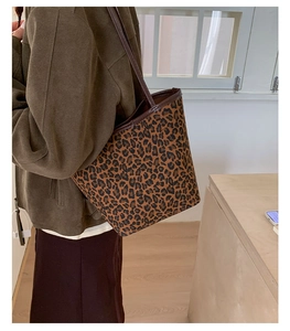Close-up of leopard print tote bag with brown leather handles and spacious interior