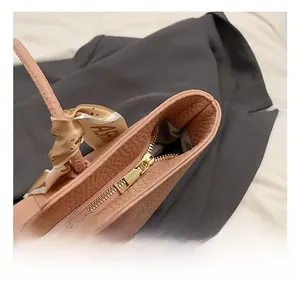 Nahaufnahme der rosa Totebag aus Leder mit goldenem Reißverschluss und Seidenschal