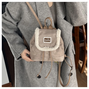 Detail of drawstring backpack with beige faux suede and white fluffy plush trim details
