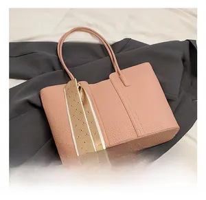 Details einer rosa Tragetasche mit Litschi-Textur und bedrucktem Seidenschal-Accessoire