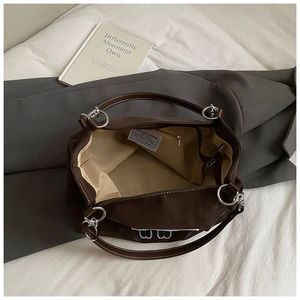 Grand cabas rétro marron foncé avec broderie et anneaux en argent sur tissu blanc