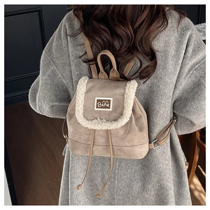 Detail view of khaki suede mini backpack with plush faux shearling trim and bear patch