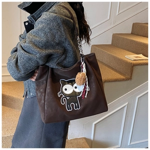 Détail du sac cabas marron foncé avec broderie chat noir et pendentif en peluche