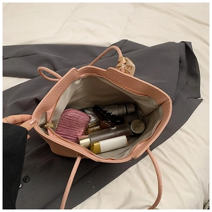 Detail der rosa Tragetasche mit geräumigem Innenraum für Kosmetik und Seidenschal-Anhänger