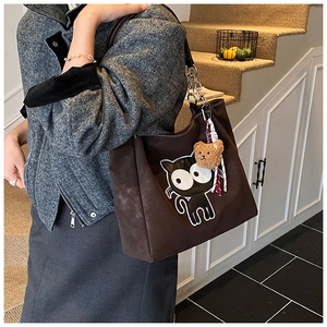 Détail du cabas chat marron foncé avec broderie, breloque ours et bandoulière chaîne