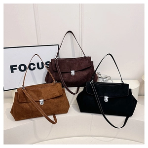 Detailed view of suede shoulder bags in brown and black with metal buckle closures