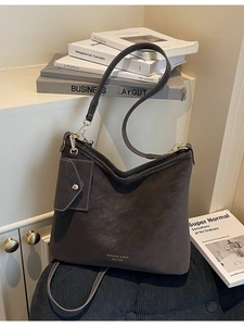 Dark gray suede crescent tote bag with adjustable shoulder straps and matching mini pouch