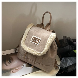Close-up of khaki faux suede backpack with white faux shearling trim and Bear patch