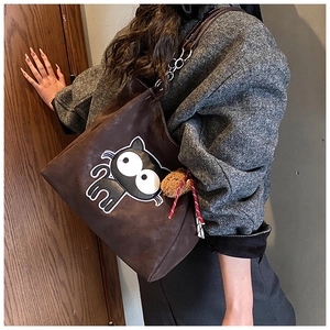 Détails du cabas en daim marron avec broderie de chat et breloque ours en peluche