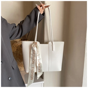 Detail einer weißen Tote Bag aus Litschileder mit dekorativem Fashion-Seidenschal am Griff