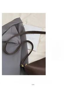 Vue détaillée de la bandoulière en cuir marron avec surpiqûres blanches et boucle dorée