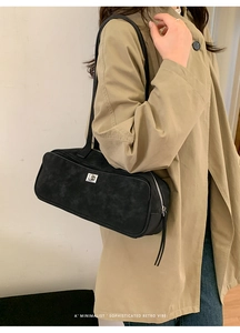 Detalle del bolso de axila en ante negro con una elegante hebilla metálica plateada
