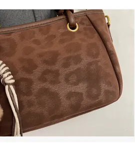Detail der Wildleder-Leopardenmuster-Textur mit Lederpaspelierung und goldener Ring-Hardware