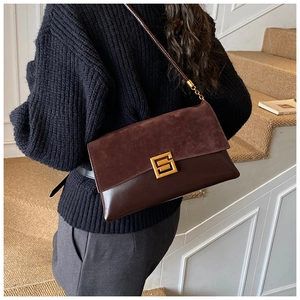 Detail of vintage brown suede patchwork shoulder bag with golden metal buckle clasp