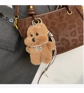 Brauner Plüschwelpen-Anhänger mit Perlenkette und Metallanhänger an Leoparden-Tasche