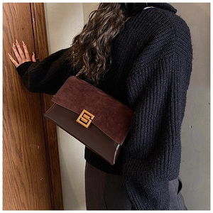 Detail of vintage patchwork shoulder bag with burgundy suede and gold square buckle