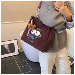 Détail du sac cabas bordeaux avec broderie chat et breloque ours en peluche