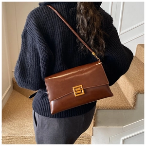 Detailed back view of a vintage dark brown envelope crossbody bag on a model