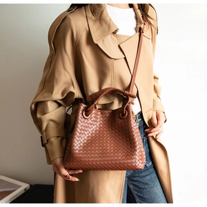 Close-up of brown leather woven bag featuring the iconic Intrecciato craft pattern