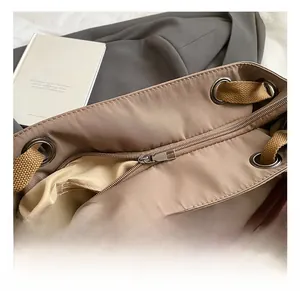 Detail showing metal zipper closure and reinforced silver eyelets on large canvas tote