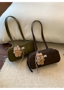 Detalle de bolsos de hombro de ante vintage con cierres plateados y colgantes de oso