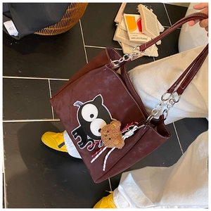 Détail du sac cabas bordeaux avec écusson chat mignon et charmant pendentif d'ours