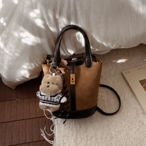 Détail du sac seau vintage en daim marron avec fermoir métallique doré élégant