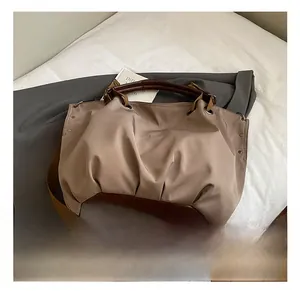 Detail showing high-capacity canvas bag with synthetic leather patches and metal rivets