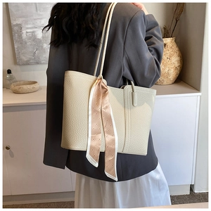 Detailansicht der cremeweißen Tragetasche mit Lychee-Muster und dekorativem Modeschal