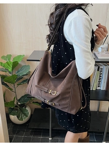 Vue détaillée du sac à bandoulière en cuir mat marron avec coutures et boucles blanches