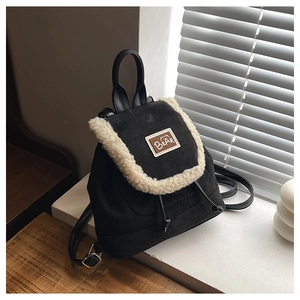Detail of vintage black matte backpack with faux sheepskin trim and brown bear leather patch