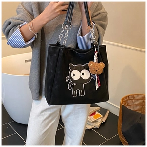 Détail du sac cabas en toile noire avec motif chat de dessin animé et bandoulière chaîne