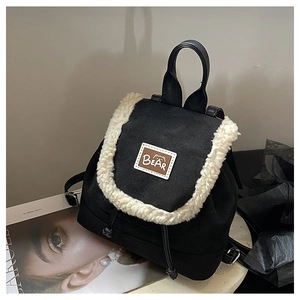 Close-up of black frosted backpack with white faux fur trim and leather bear patch