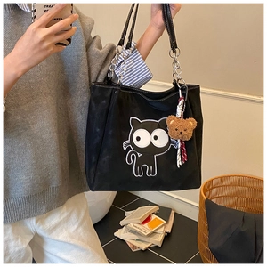 Détail du sac cabas chat de dessin animé noir avec chaînes en métal et breloque ours