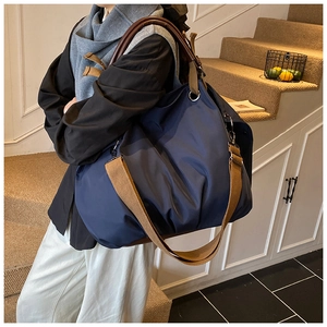 Detail showing the large navy blue canvas tote bag on model for a commuting look
