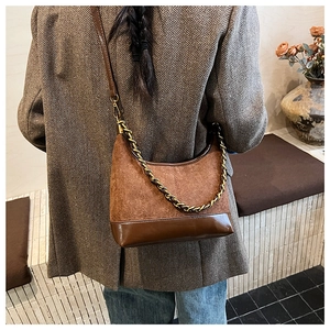 Brown suede hobo bag with vintage gold chain shown on model in a blazer jacket