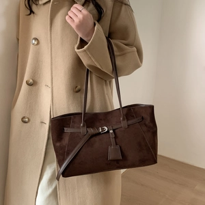 Detail of dark brown faux suede tote bag with slim belt buckle and silver metal hardware