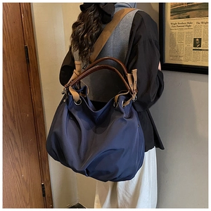 Detail of navy blue canvas tote bag showing adjustable strap and large capacity texture