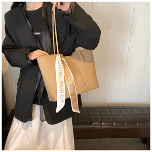 Detail der beige Tote Bag mit Litschistruktur und dekorativem Modeseidenschal am Griff